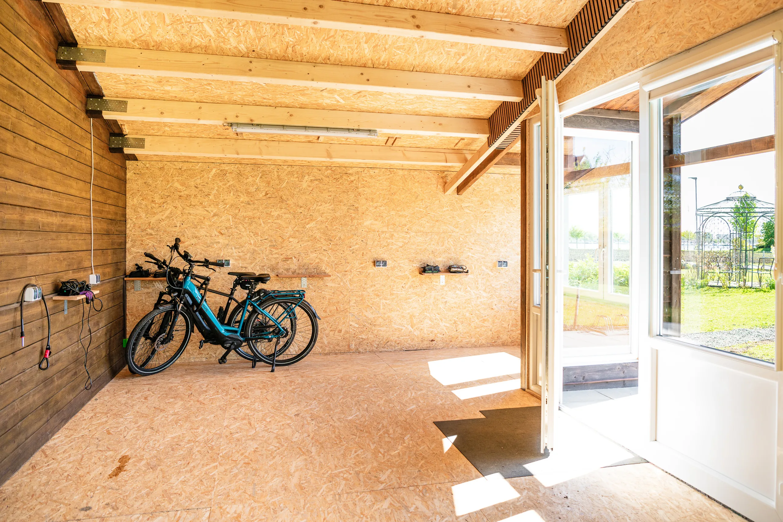 Abschließbares Fahrradhaus im Strandhotel Garni Fehmarn — Innenansicht mit E-Bikes.